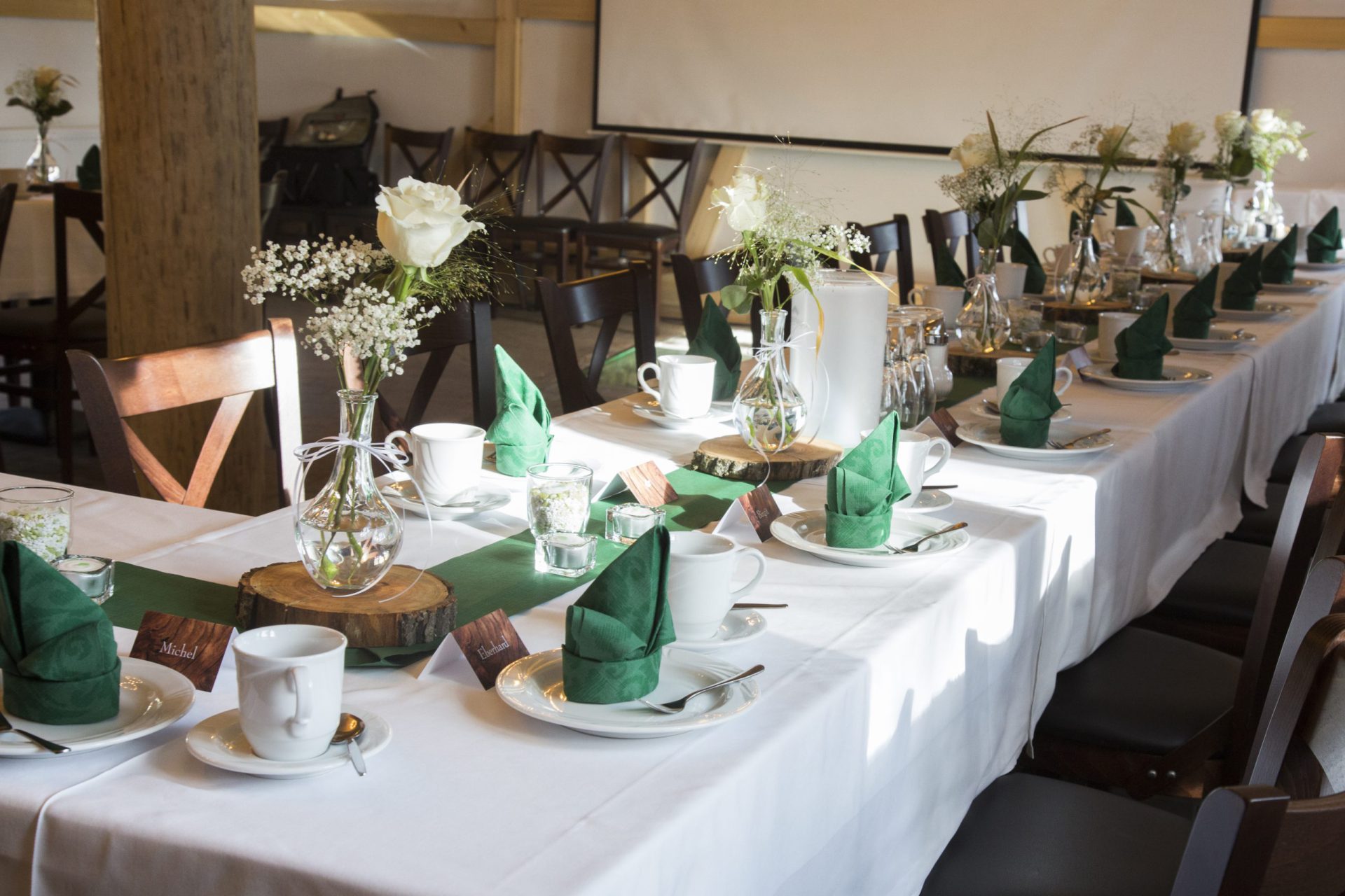 Festlich eingedeckte Tafel mit Servietten, Blumen und Gedecken