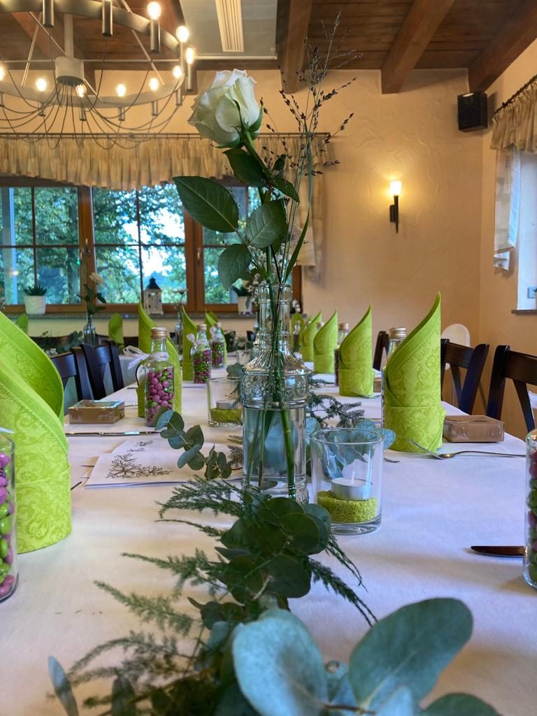 Festlich eingedeckte Tafel mit Servietten, Blumen und Gedecken