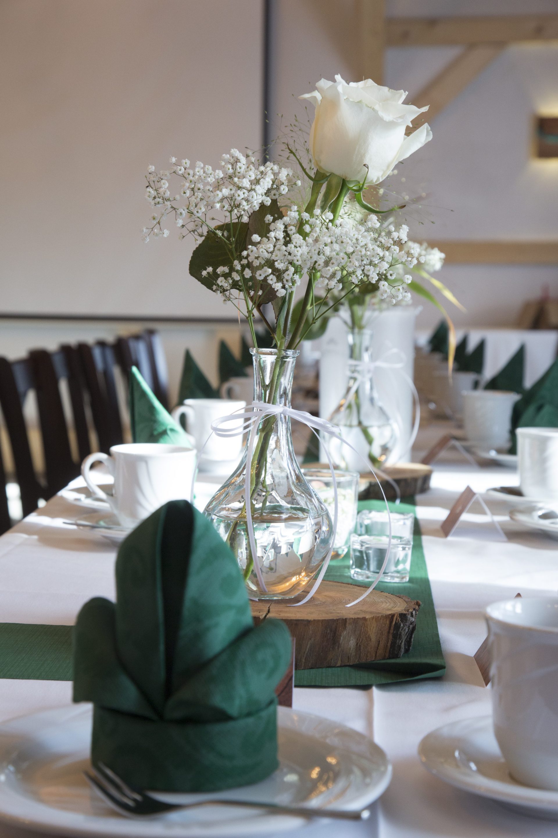 Tischdekoration mit Blumen und gefalteter Serviette