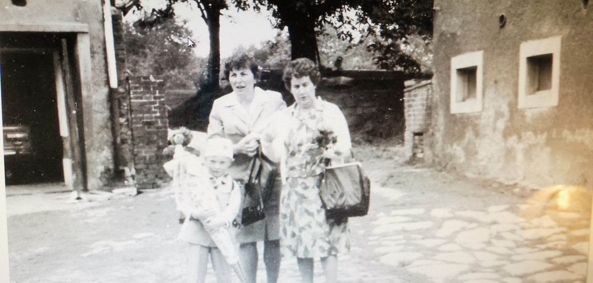 Historische Schwarzweißaufnahme der Familie Fischer auf dem Hof