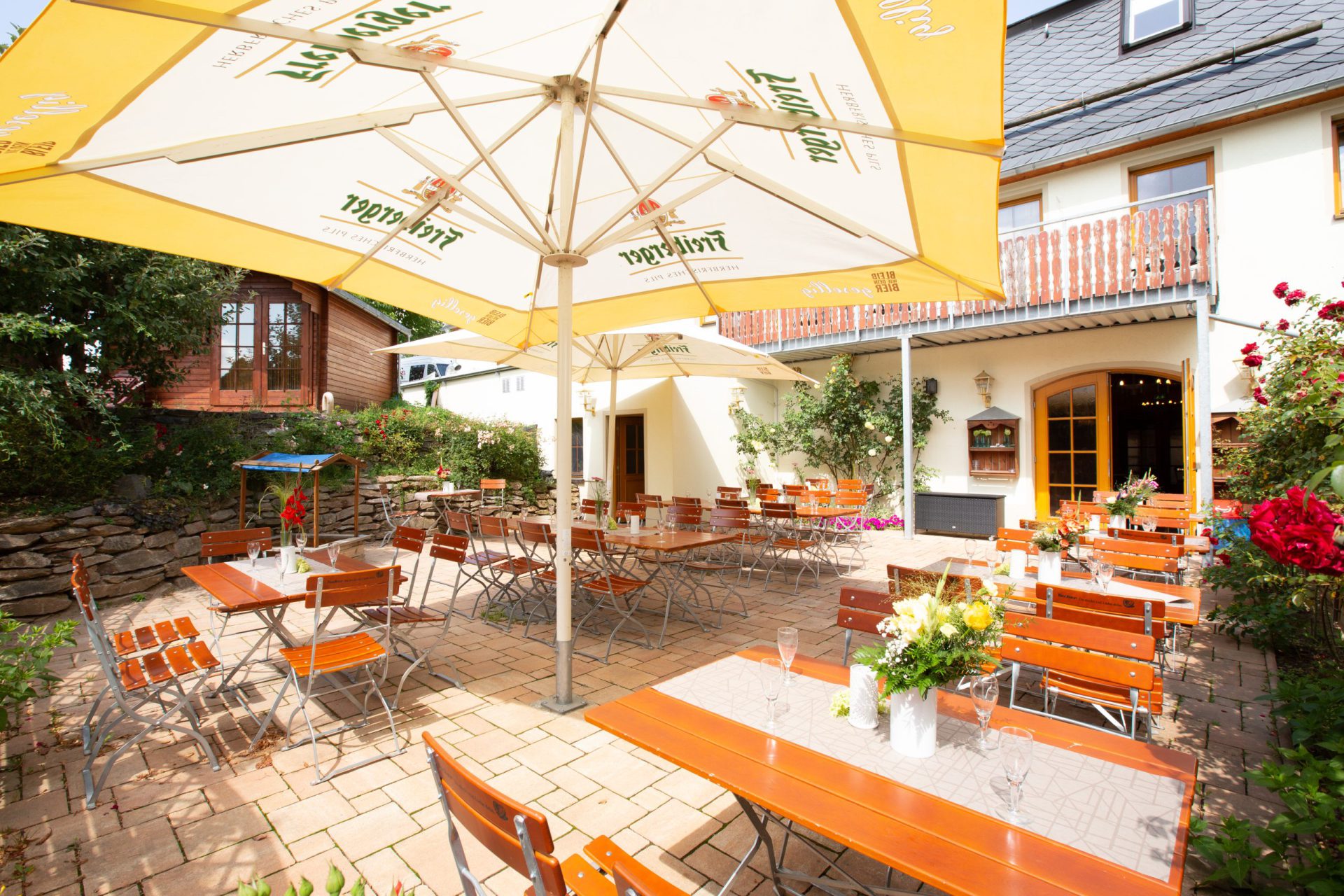 Biergarten im Innenhof mit Sonnenschirmen und Bierbänken