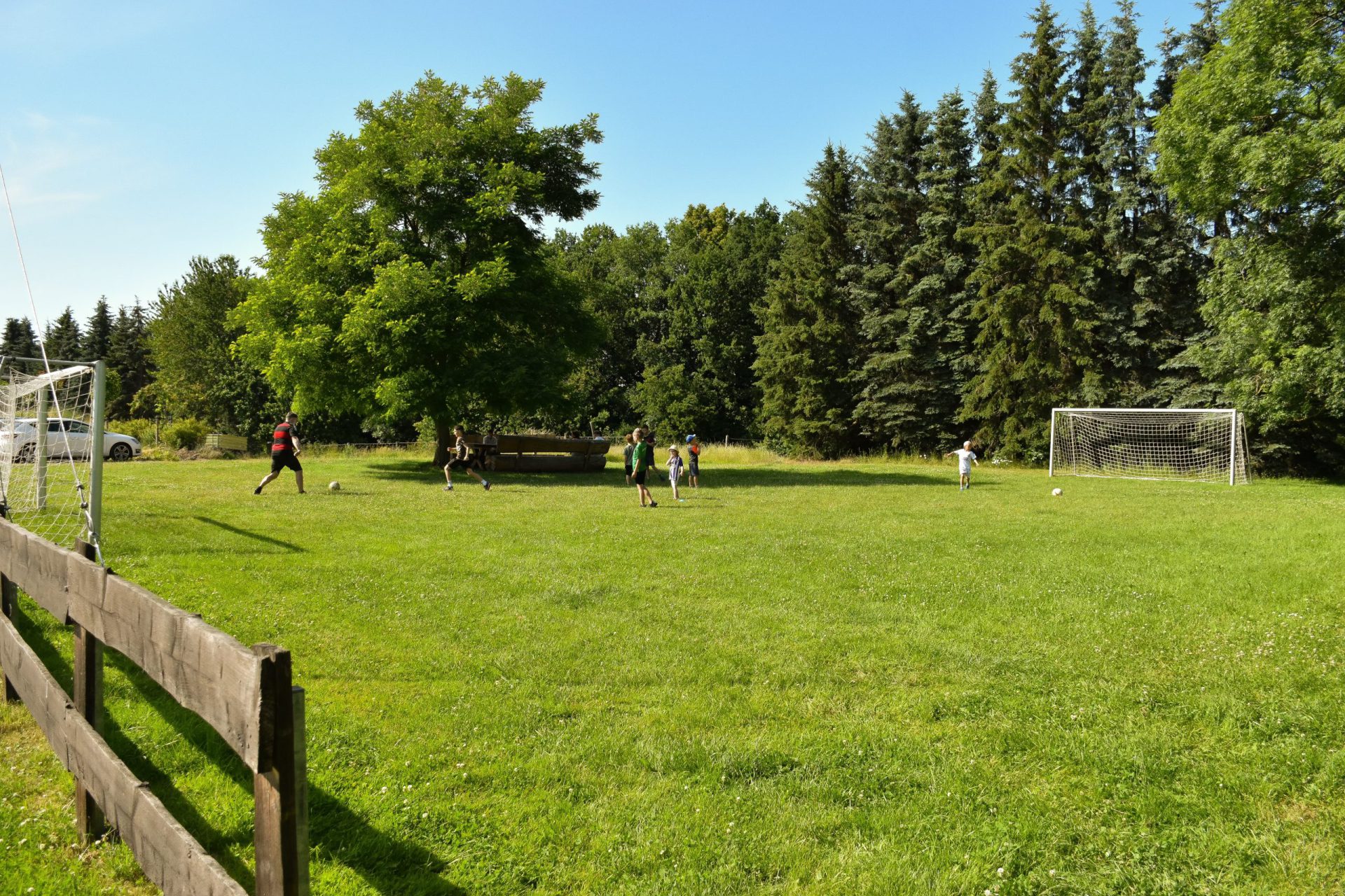 Rasenplatz mit Fußballtoren neben dem Hof