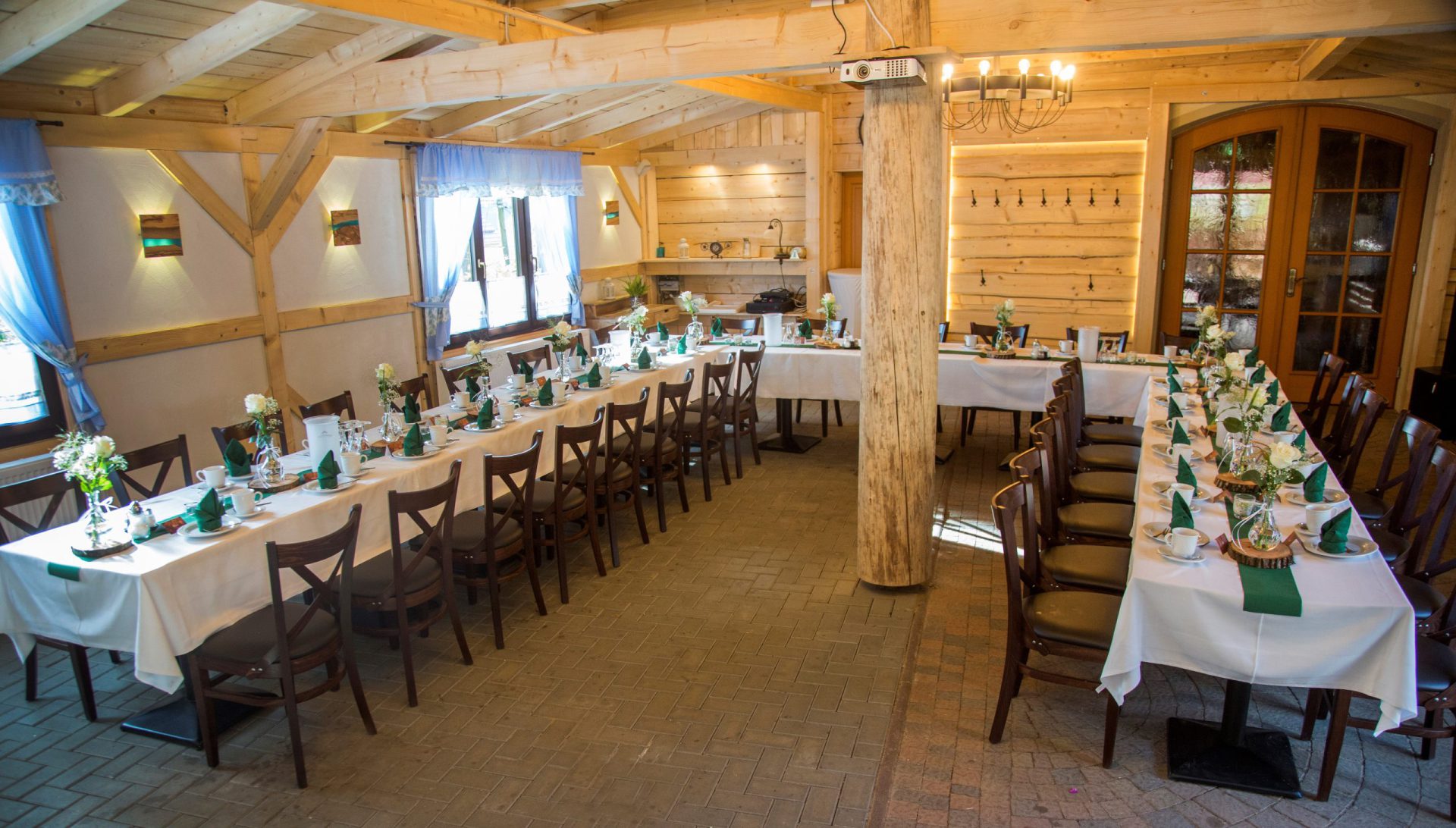 Holzhütte mit langen, festlich eingedeckten Tafeln