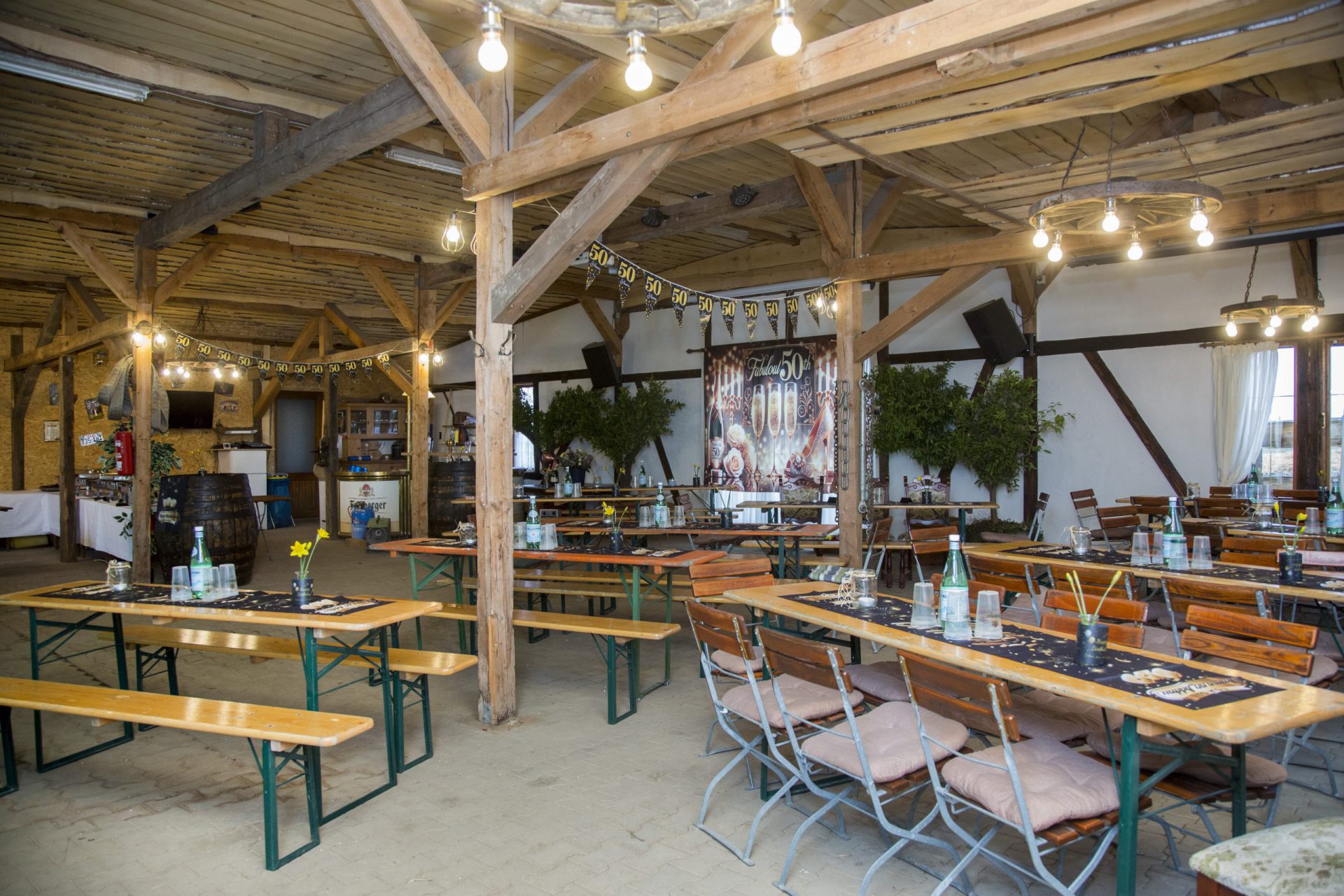 Party-Scheune mit langen Tischreihen und Lichterketten