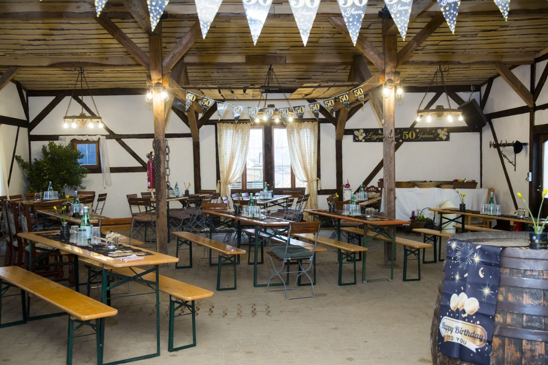 Party-Scheune mit langen Tischreihen und Lichterketten