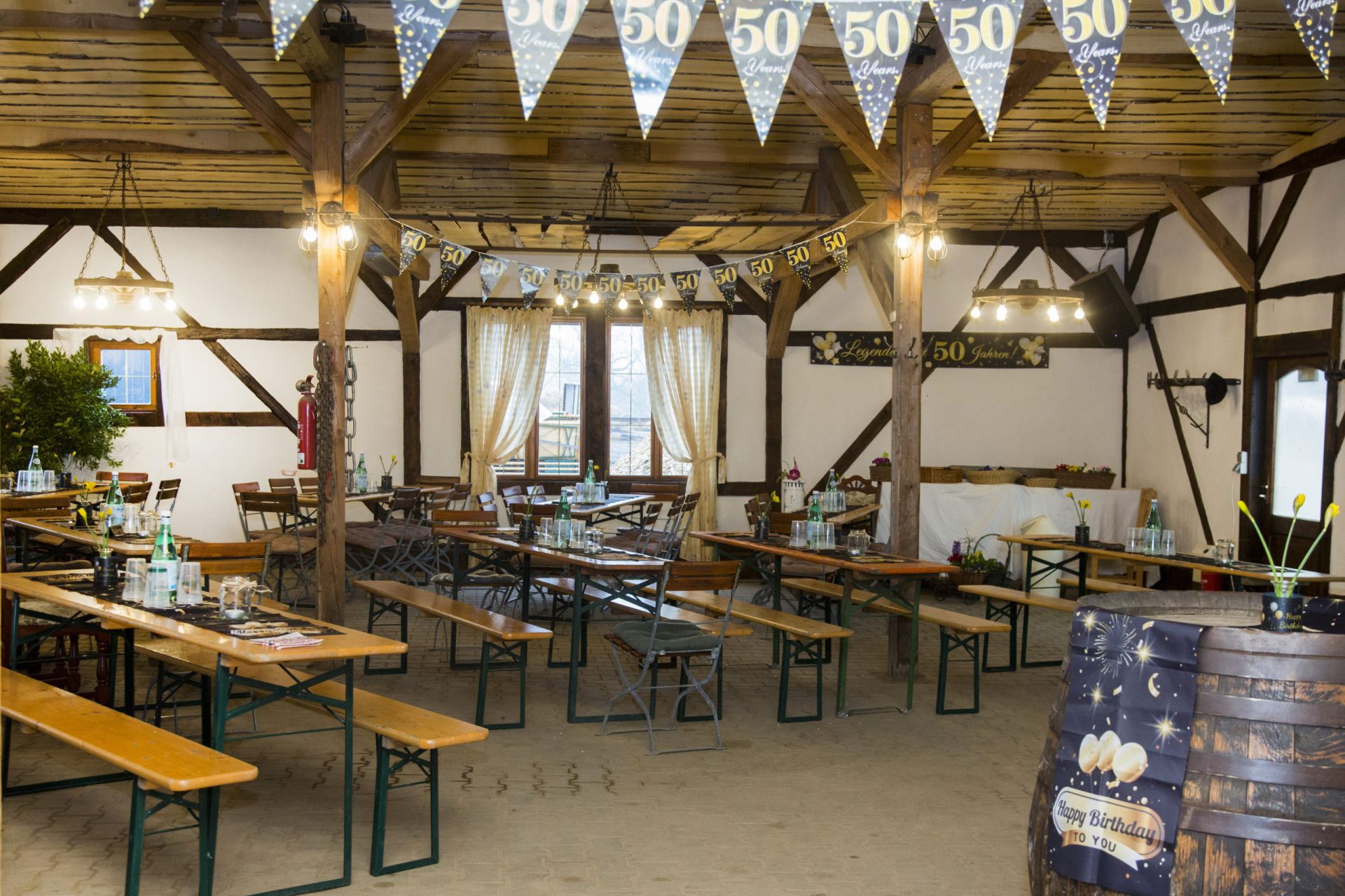 Party-Scheune mit langen Tischreihen und Lichterketten