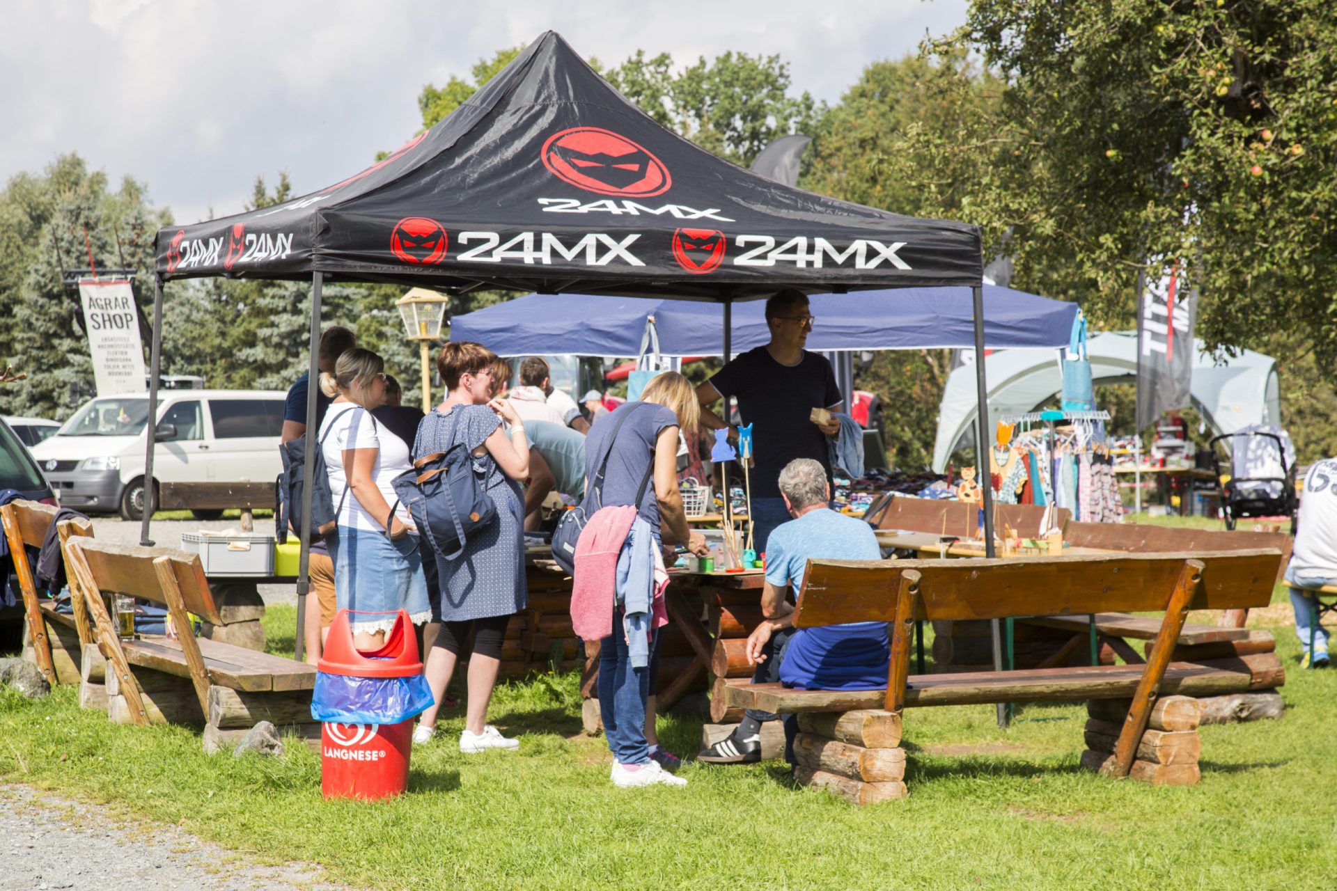 Besucher an Biertischgarnituren beim Hoffest