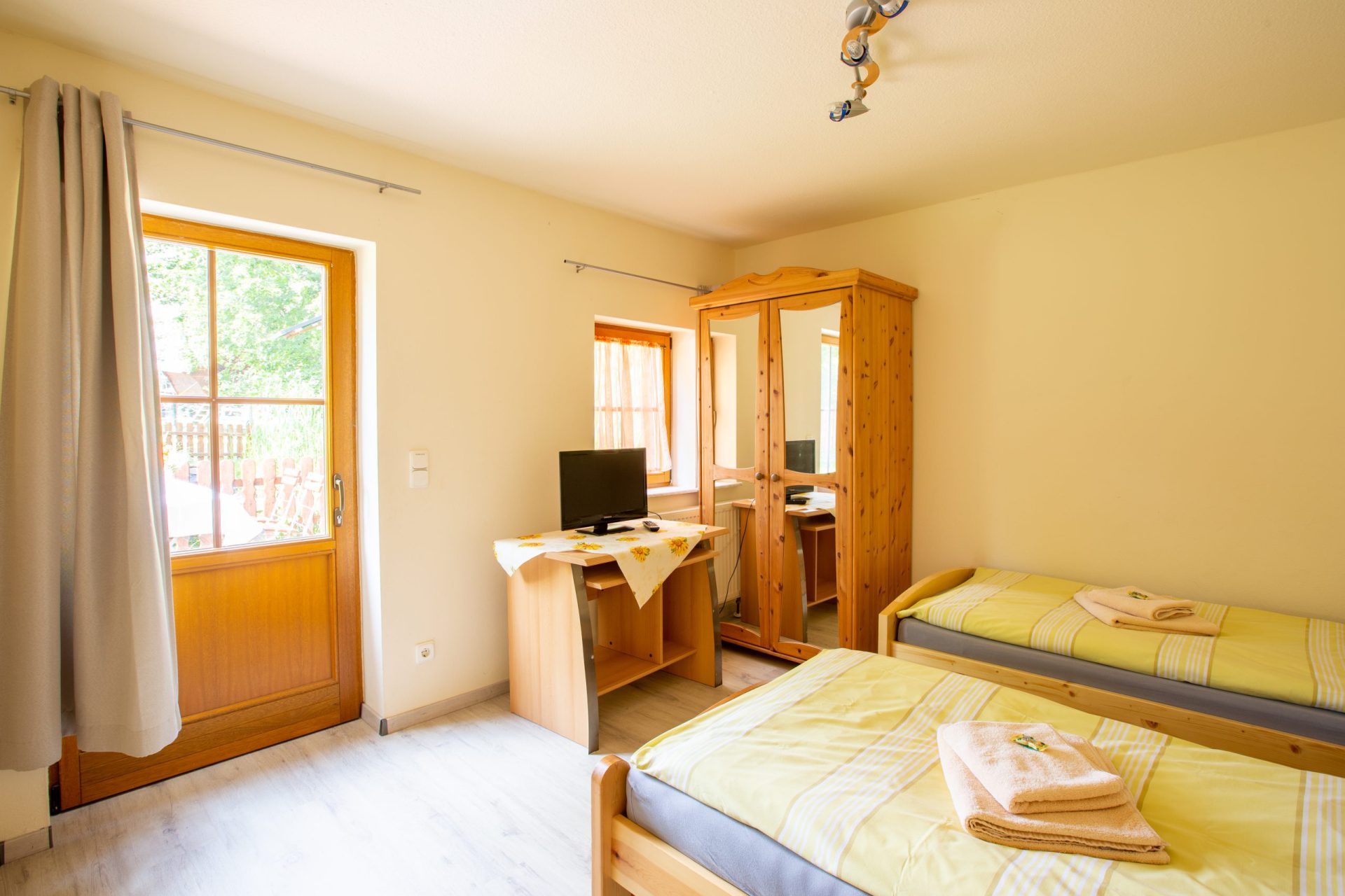 Einzelzimmer mit Bett, Schrank und Schreibtisch